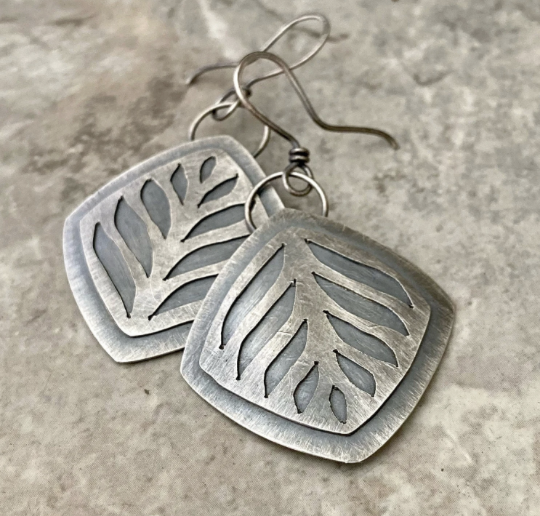 Handmade pierced metal leaf earrings cut with a jeweler’s saw